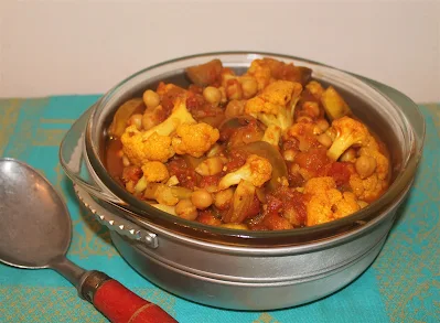 Serving Stewed Indian-spiced eggplant, cauliflower, and chickpeas.