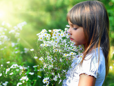 foto de niña oliendo flores 