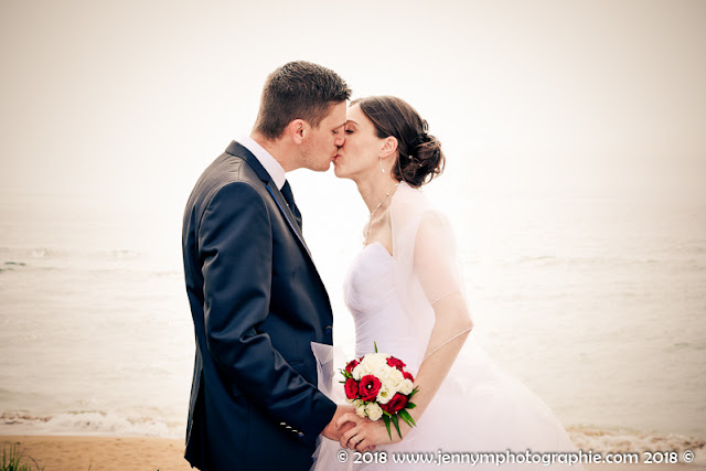 portrait mariés, photo couple mariage au bord de mer, bisou des mariés, bouquet mariée roses blanches et rouges