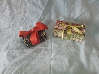 The two sewing kits from before, rolled up and tied shut with ribbons.