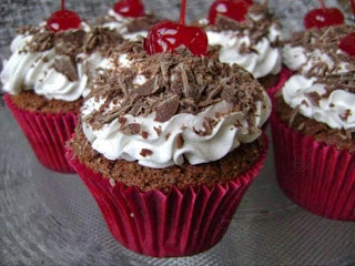 cupcake de chocolate com chantilly e cerejas