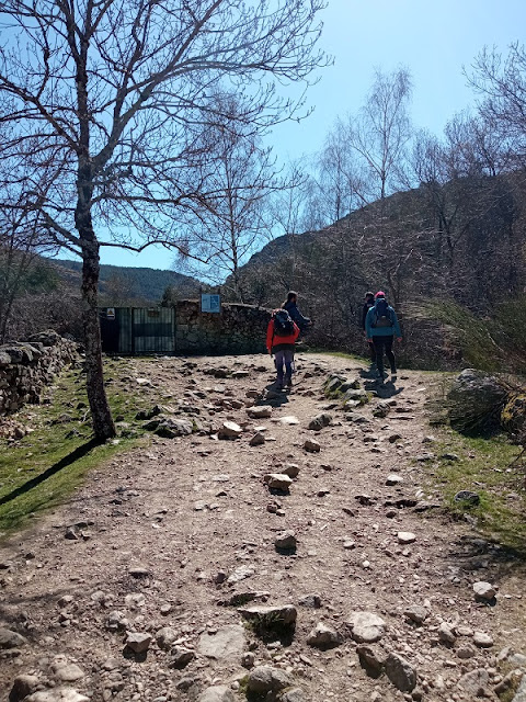 El sendero bordea la valla por la derecha, juntándose al río