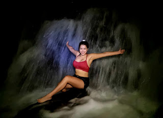 Chica disfrutando de una cascada subterránea dentro de la cueva de Humanti, en Archidona Napo, maravillándose con la belleza y serenidad de esta maravilla natural oculta.