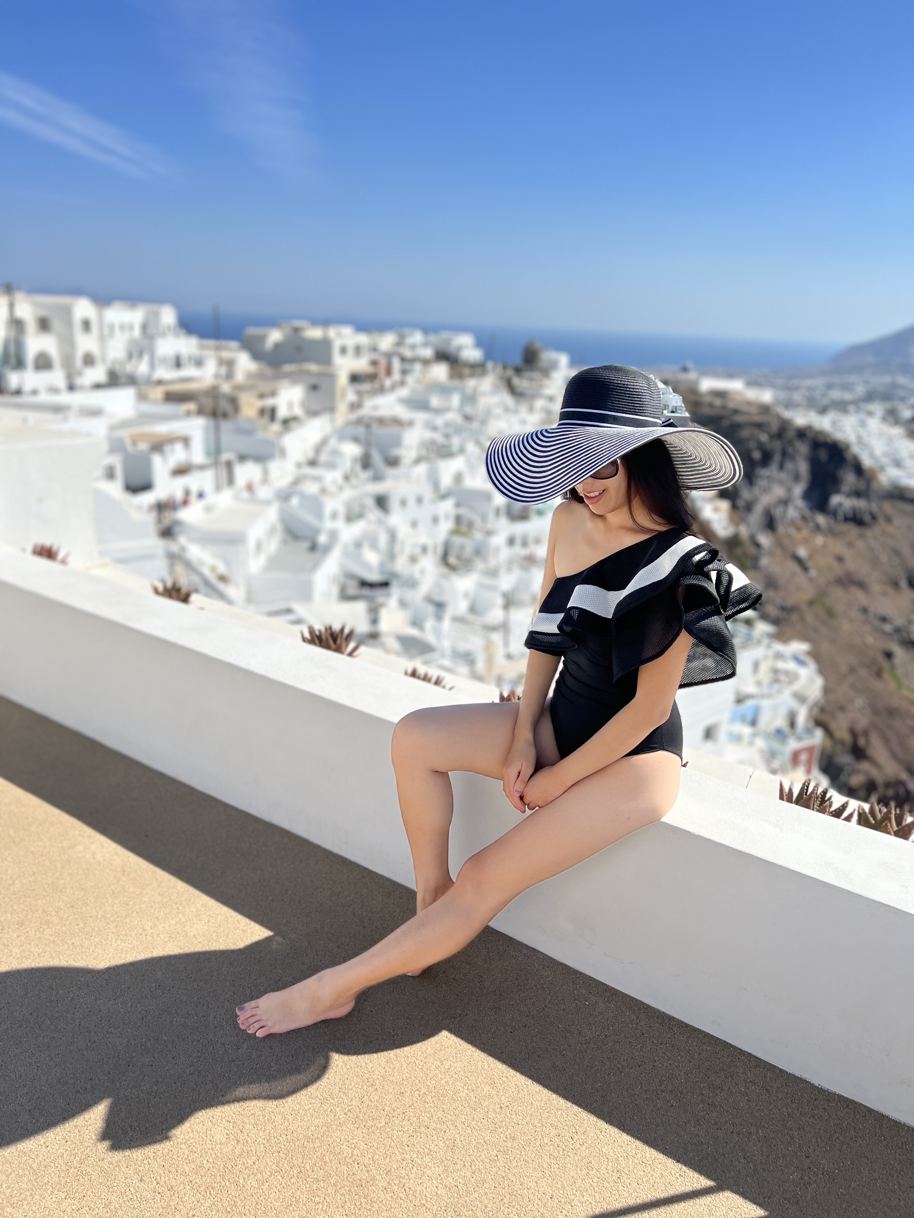 Caldera View in Santorini_Imerovigli, Santorini_Greek Islands_Aegean Sea_One Shoulder Black and White Ruffle One Piece Swimsuit_Black and White Floppy Hat_Olia VIllas and Suites_Adrienne Nguyen