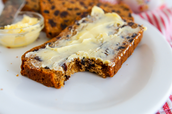Bara Brith - Speckled Bread from Wales, slice spread with butter and bite taken