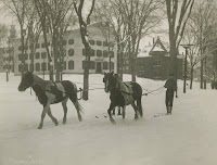 A black and white photograph of men on skis being pulled by horses.