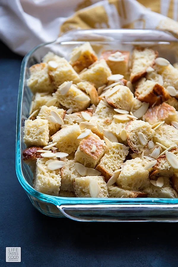 Soaked bread cubes topped with slivered almonds for Overnight French Toast Casserole