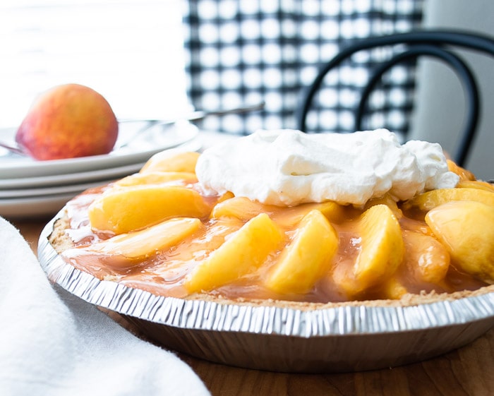 fresh peach pie with glaze and whipped cream