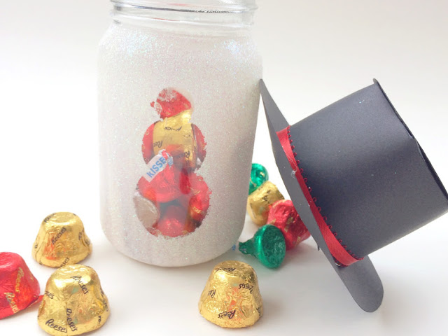 Make a snowman that will last all year long and is super cute with a bit of sparkle, a cute magic hat, and some yummy chocolate candies.  This snowman gift jar is the perfect Teacher gift, neighbor gift, or gift for your best friend.  It's easy and worth every little bit of glitter.