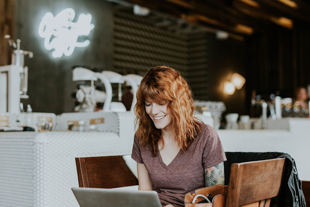 woman smiling at laptop:Photo by Brooke Cagle on Unsplash