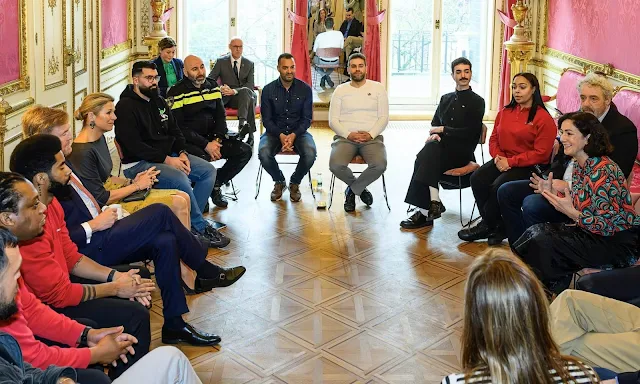 Queen Maxima wore a yellow lace skirt by Natan and navy blue top by Natan, and a grey cashmere cape by Natan. Mayor Femke Halsema