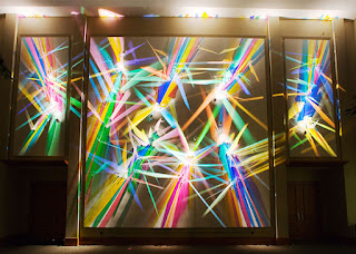 Stephen Knapp's Lightpainting Art shows high polished glass of varing angles to create different colors in his light paintings, shown here with three large frames floating in front of the glass and lights with vivid color spectrums.