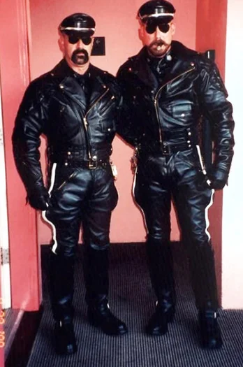 Two similar looking Leatherman wearing sunglasses, hats and leather pants and biker jacket