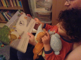 My boy with Daddy reading a book with his beloved elephant and bear toys 