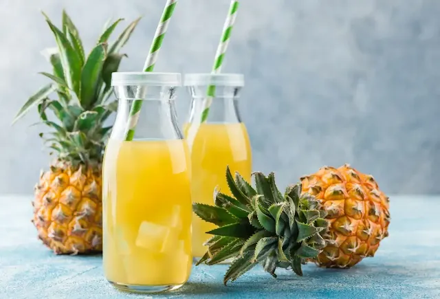 two pineapples and pineapple juice jars