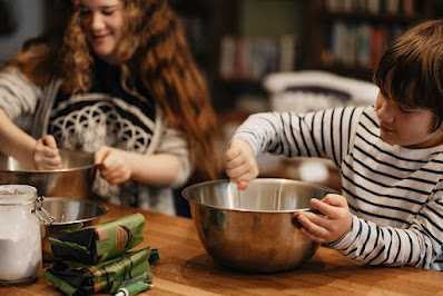 Two older children baking