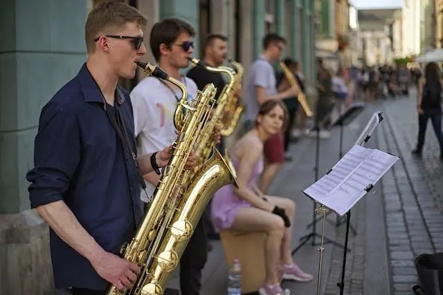Hombre tocando su saxofón en publico. Efectos de la música en el cerebro.