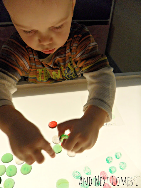 Toddler playing with glass stones on the light table