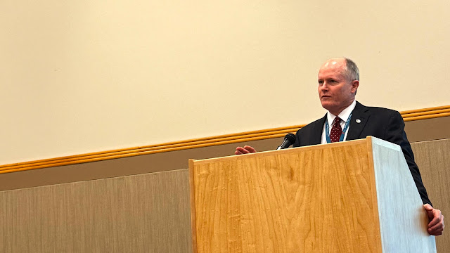 Dr. Drew Fallis stands at a podium