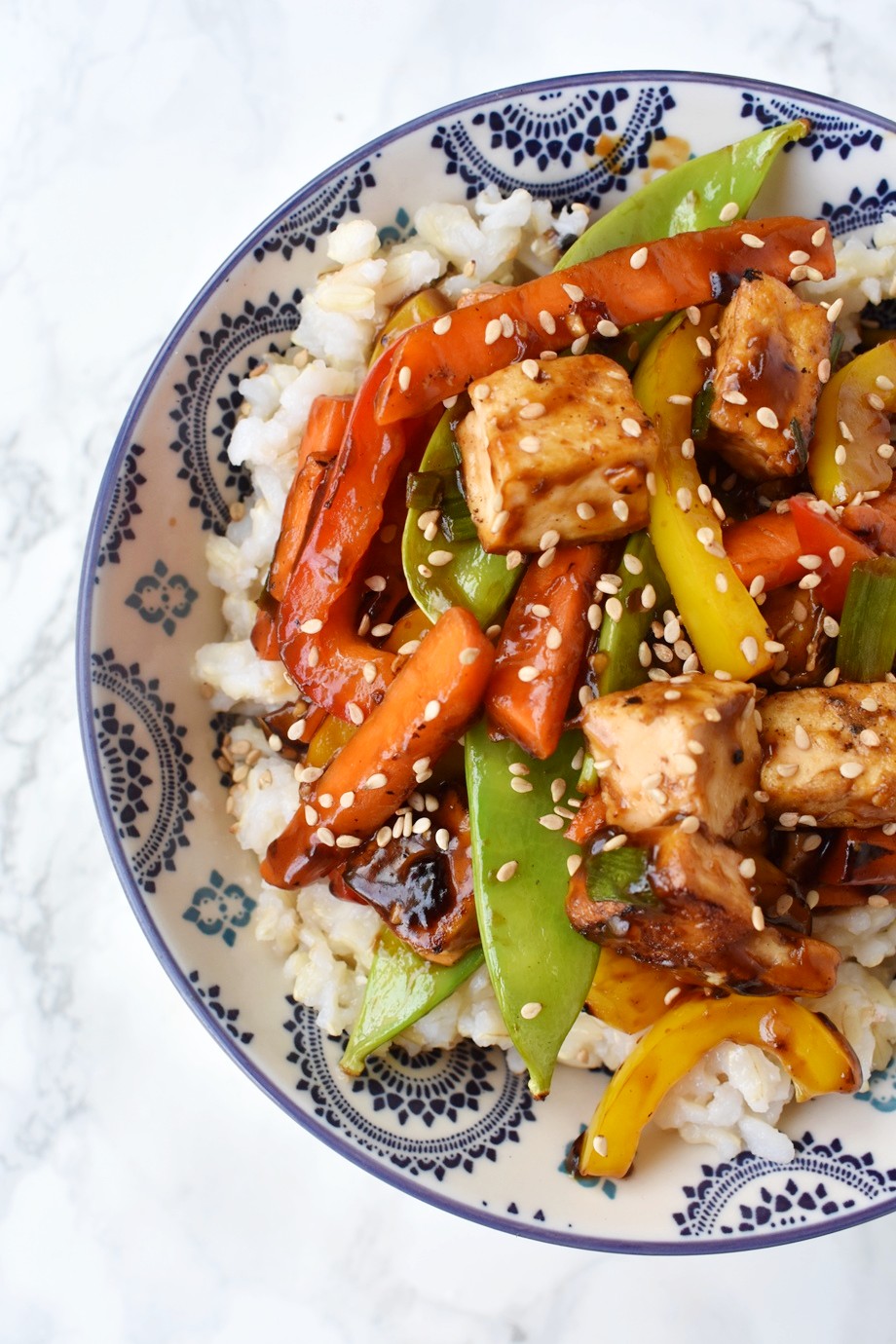 Crispy Tofu Stir-Fry is loaded with crispy flavorful tofu, bell peppers, carrots, peapods and a delicious soy garlic ginger sauce! #tofu #stirfry #rice #asian #chinese #vegetarian #veggies #healthy