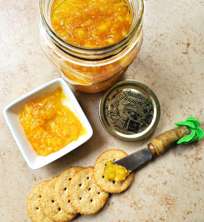 homemade marmalade with navel oranges, fresh lemon in a mason jar spread on crackers