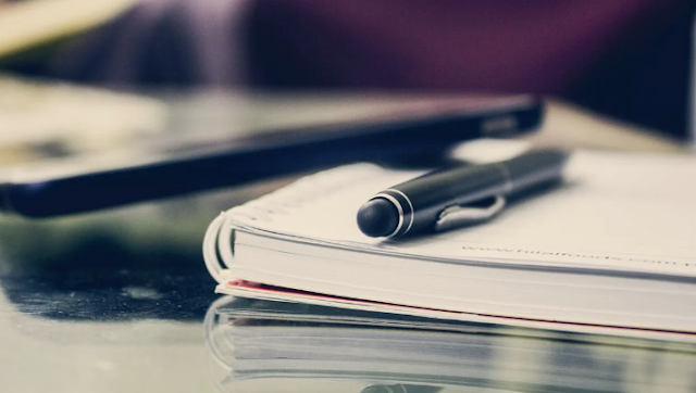 pen on top of a notebook