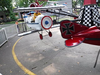 boy riding the Red Baron airplane ride at Adventureland in Altoona, Iowa