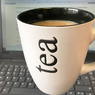 Mug of tea in front of laptop