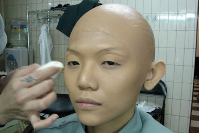 the transformation begins with cover hair with bald wig and basic makeup