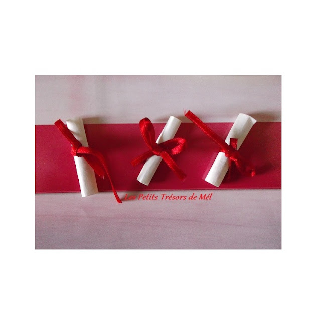 Rouleaux de parchemin miniatures fabriqués en papier et noués avec du ruban rouge.