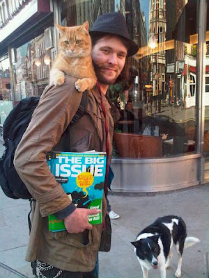 Bob the Street Cat lying across James Bowen's shoulders.