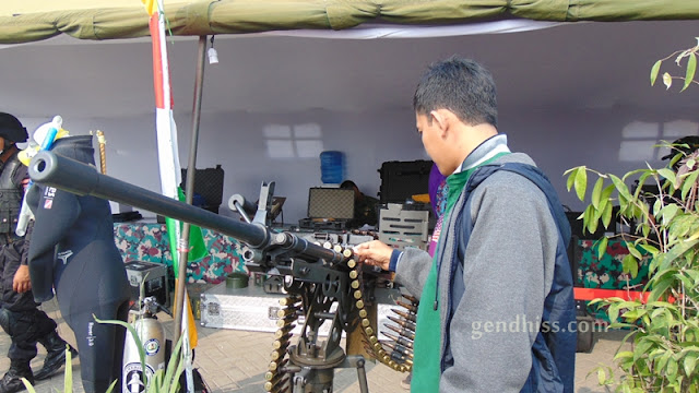 Suami sedang menilik peluru di pameran TNI