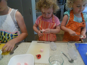 Snipping marshmallows with scissors to decorate biscuits. Snipping marshmallows with scissors to decorate biscuits.