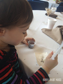 young child writing with a quill and ink