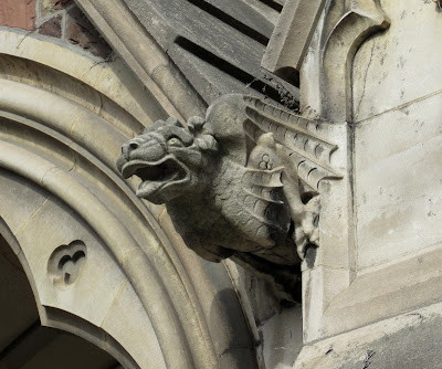 Stone dragon jutting from the side of a building, near the roofline