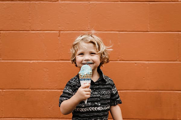 Un niño come un helado con una sonrisa de oreja a oreja.