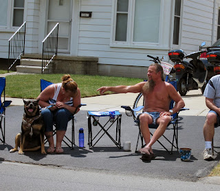 shirtless guy and dog at parade, long beard