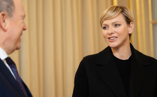 Princess Charlene wore a black Giovanni sleeveless jacket by Max Mara, and black cashmere sweater. Dries Van Noten Beau