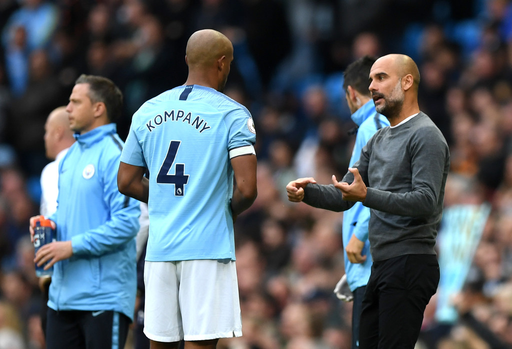 Josep Guardiola, Manager of Manchester City speaks with Vincent Kompany of Manchester City during the Premier League match between Manchester City and Burnley FC at Etihad Stadium on October 20, 2018 in Manchester, United Kingdom