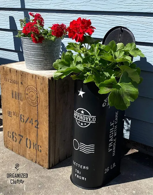 Photo of stenciled garden junk, a crate and a mailbox planter.