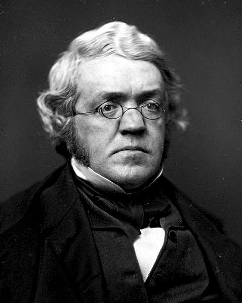 older man with gray hair and glasses in a formal 19th-century photo