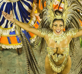 Feathers and glitter: A reveller of Portela samba school performs during the first night of Carnival parade.