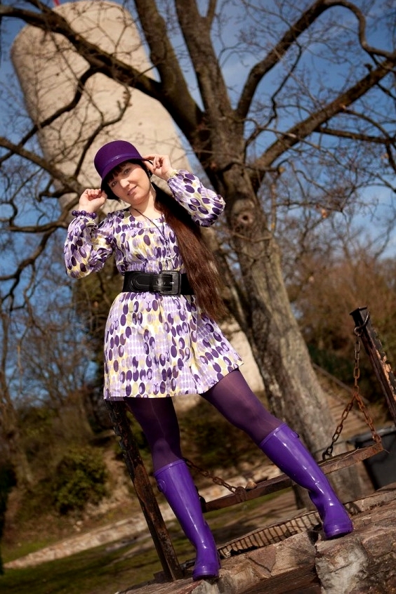Pretty woman wearing mini dress, shiny purple tights and purple wellies