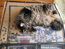 cat lounging on half-completed puzzle of Neuschwanstein Castle
