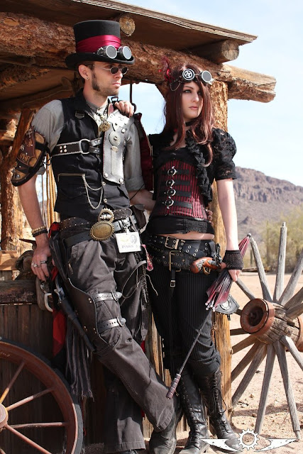 Steampunk couples costume, weird west, wild west fest. man and woman in red and black steampunk clothing.