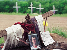 A photo of David Koresh rests beside a wooden cross as part of a monument erected in Waco, Texas, by supporters of the Branch Davidian leader and founder, Friday, April 30, 1993. (AP Photo/NewsBase) Read more: https://www.smithsonianmag.com/history/true-story-waco-still-one-contention-180968002/#Y7OBbhH61PI6iXuX.99 Give the gift of Smithsonian magazine for only $12! http://bit.ly/1cGUiGv Follow us: @SmithsonianMag on Twitter