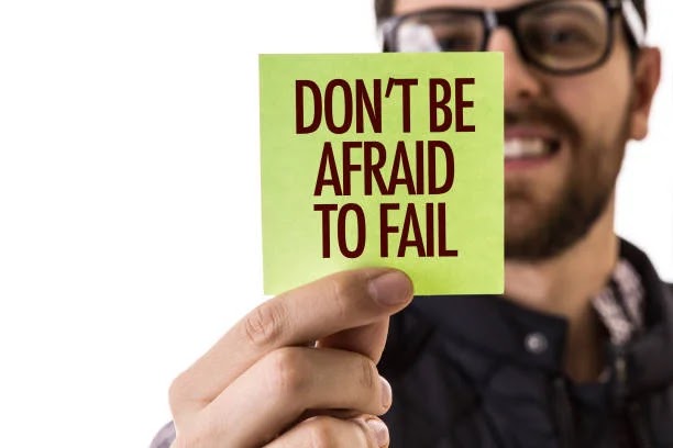 A man holding a card with words written on it saying , don't be afraid