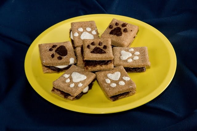 scrumptious looking graham cracker sandwiches filled with yogurt and carob, with a paw print design on top