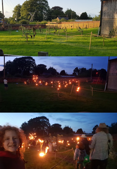 Just So Festival Fire Garden pathway with fire torches in the day and at night lit up