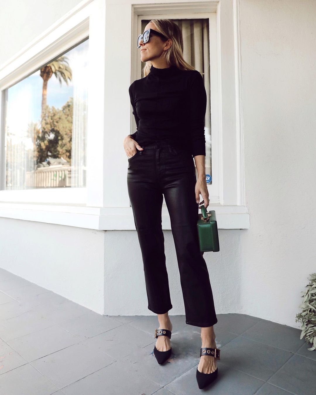 Instagram star Jacey Duprie in an all-black outfit idea with turtleneck faux leather jeans, and pointed-toe mule heels
